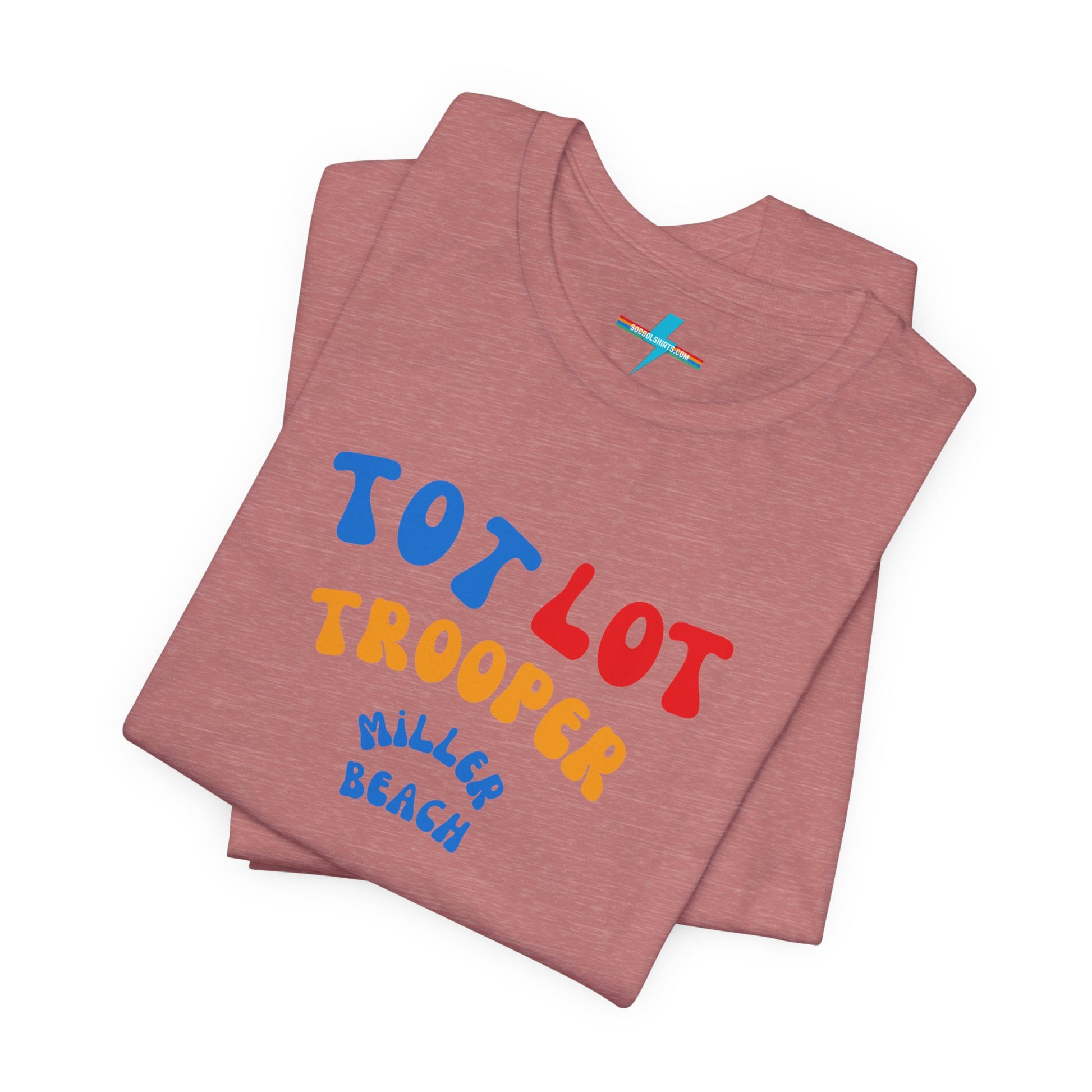 A green unisex jersey short sleeve tee from Printify, featuring colorful text on the front that reads "TOT LOT TROOPER MILLER BEACH" in blue, red, yellow, and orange letters. The shirt is displayed against a plain white background.