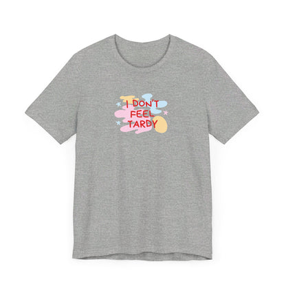 The "I Don't Feel Tardy - 1980s Retro - Unisex Jersey Short Sleeve Tee" from Printify is a light pink jersey shirt that features the bold, colorful text "I DON'T FEEL TARDY" prominently at its center. This design exudes retro vibes with small star shapes and abstract splashes of blue, yellow, and pink, laid flat against a plain background to channel pure Van Halen T-shirt energy.