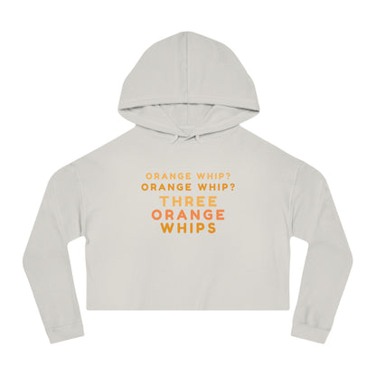 A stylish and comfortable Black Camo cropped hooded sweatshirt from Printify, this "Three Orange Whips - Blues Brothers" women's hoodie features the iconic text "Orange Whip? Orange Whip? Orange Whip? THREE ORANGE WHIPS" in bright orange letters on the front. It includes a front pocket and drawstring-adjustable hood.