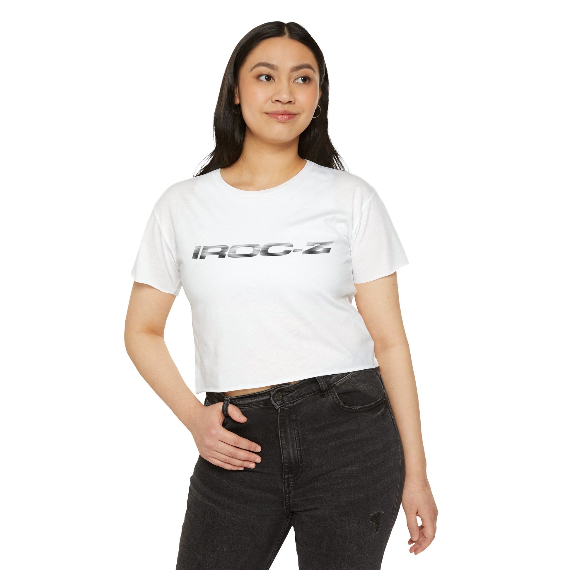 A grey, short-sleeve, rounded-neckline Women's Festival Crop Top by Printify, featuring "IROC-Z" printed in bold black letters across the chest. Perfect for any festival, this Chevrolet Iroc Z-inspired top from the 1980s stands out against a plain white background.