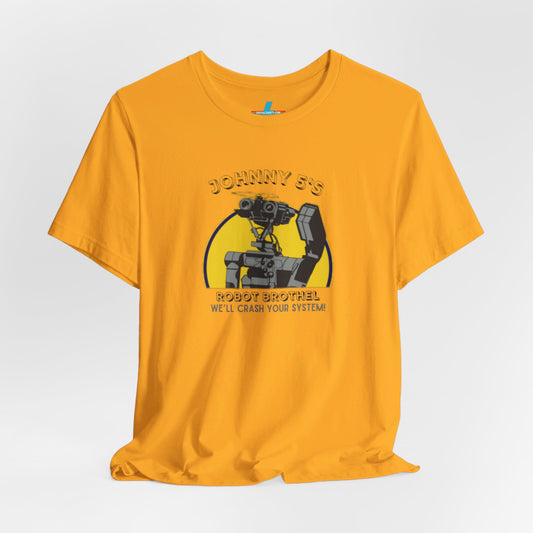 A vibrant orange unisex jersey short sleeve tee from Printify showcases a graphic of a small robot detailed in black and grey. Above the robot, retro robotics text reads "Johnny 5’s Robot Br*thel," while below, it says "We'll Crash Your System!" in a smaller font.