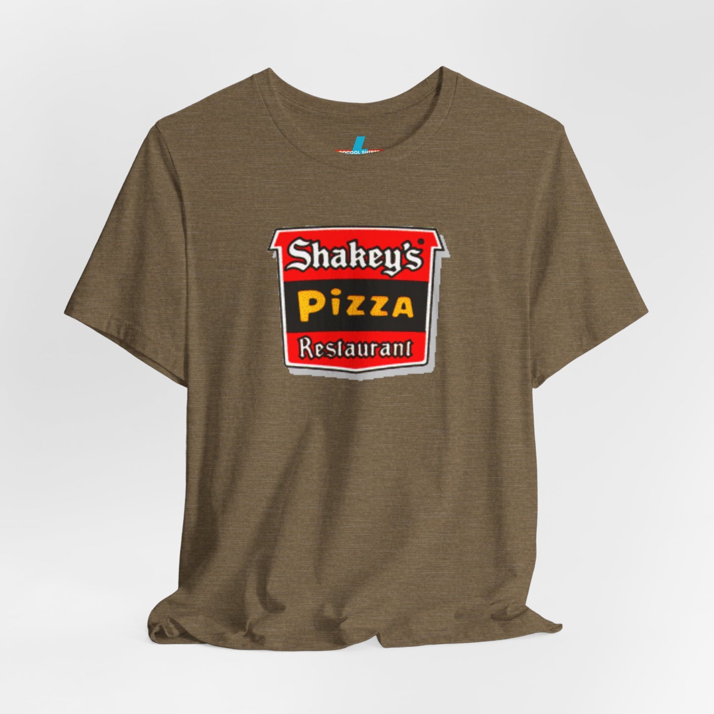 A black Shakey's Pizza - 1980s Retro Logo - Unisex T-Shirt by Printify hangs against a white background. The shirt features a colorful graphic with the text "Shakey's Pizza Restaurant" in white, yellow, and black lettering on a red background, resembling vintage pizza joints signage. This retro tee brings nostalgic vibes of classic pizzerias.