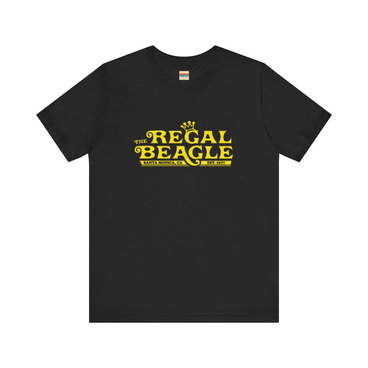 The Printify Regal Beagle - Three's Company Unisex Jersey Short Sleeve Tee, in black, showcases "The Regal Beagle, Santa Monica, CA, Est. 1977" text in a yellow vintage-style font. Crafted from 100% Airlume combed cotton for superior comfort.