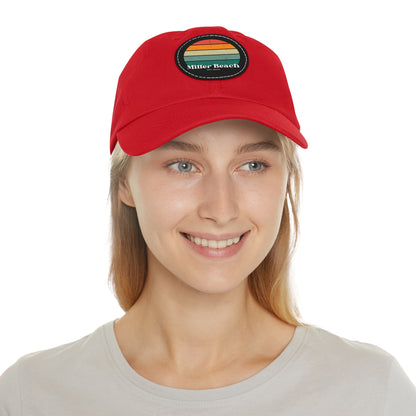 The Miller Beach Retro Sunset - Dad Hat with Leather Patch (Round) by Printify is a pink baseball cap crafted from bio-washed chino twill for added comfort. It features a PU leather patch adorned with horizontal stripes in red, orange, yellow, green, and blue. Below the stripes, "Miller Beach" is embroidered in white. An adjustable strap at the back ensures a perfect fit.