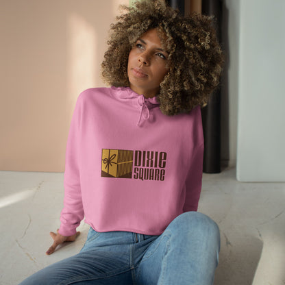 Pink cropped hoodie from Printify, showcasing a yellow and brown "Dixie Square" logo with a ribbon design on the front, reminiscent of the iconic Dixie Square Mall in Harvey, IL from the Blues Brothers era.