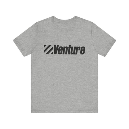 A unisex jersey short sleeve tee from Printify, featuring a classic 1980s Venture Stores logo printed in bold black letters across the chest on a gray fabric, is showcased against a plain white background.