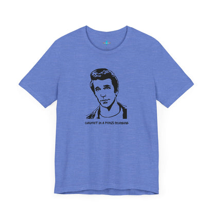 A white unisex jersey short sleeve tee by Printify, named "Caught in a Fonzi Scheme - Happy Days - Retro," features a black and white illustration of a person with a serious expression and styled hair, perfectly capturing the nostalgic apparel vibe. Below the illustration, the text reads "CAUGHT IN A FONZI SCHEME," making it an ideal Happy Days tribute shirt.