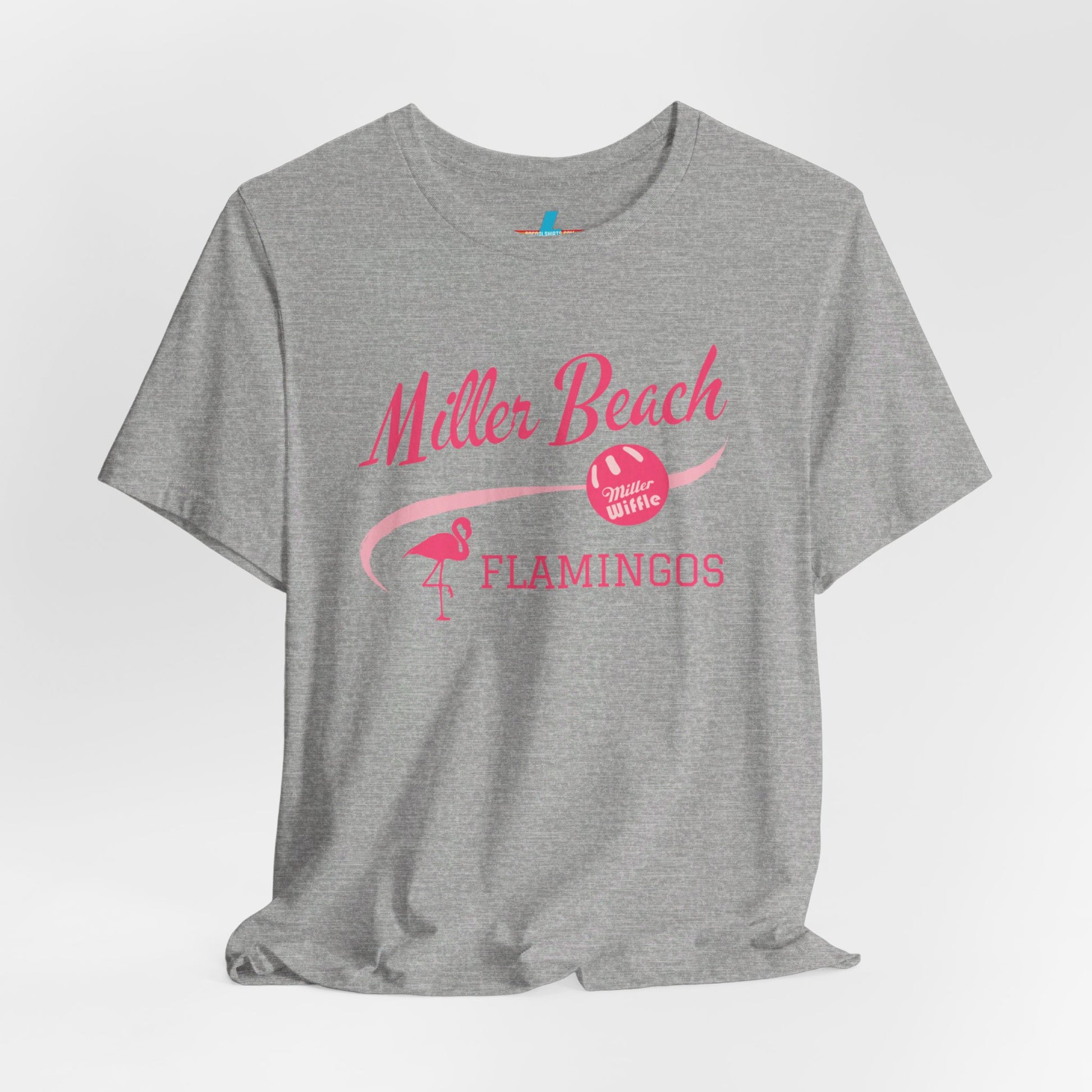 Printify offers the Miller Beach Flamingos WWBC - Unisex Jersey Short Sleeve Tee, featuring a light pink T-Shirt adorned with "Miller Beach Flamingos" and a volleyball graphic in pink. This design also includes an illustration of a flamingo, celebrating their participation in the World Wiffel Ball Championship. The shirt is showcased against a minimalist, white backdrop.