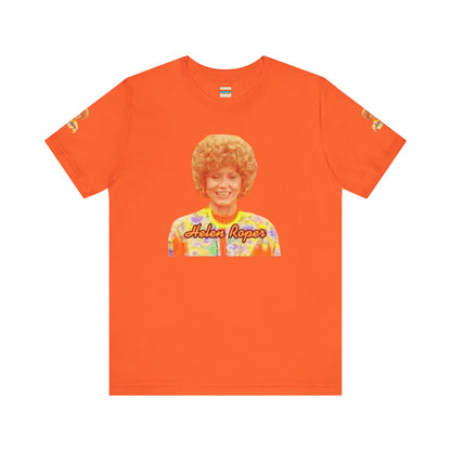 A lavender-colored Helen (Mrs.) Roper Three's Company - Unisex Jersey Short Sleeve Tee by Printify is hanging on a wooden hanger against a white background. This T-shirt features an image of a smiling person with curly hair wearing a colorful blouse, with the text "Helen Roper" underneath the image. Both sleeves have identical designs, making it perfect Three's Company merchandise.