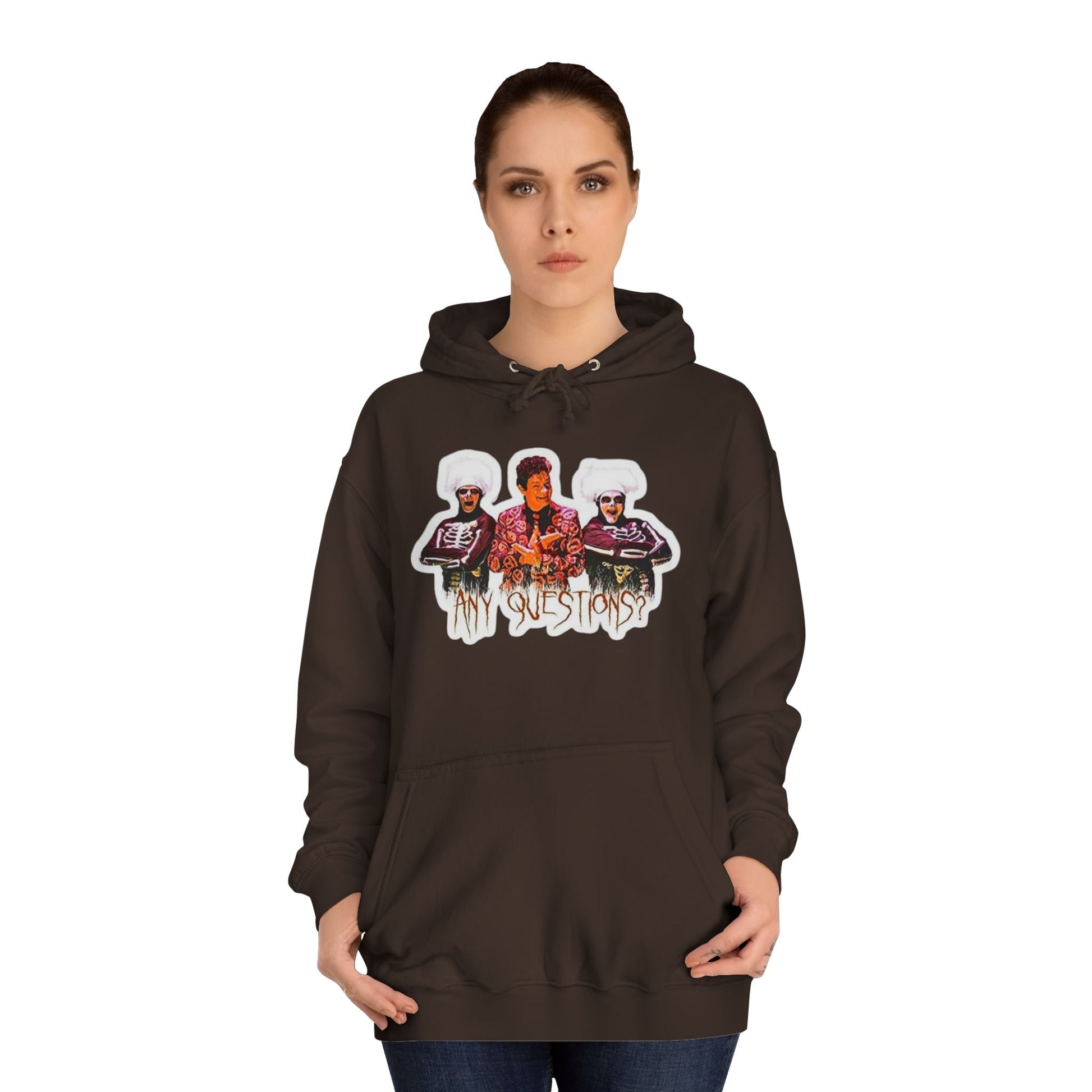 The David S Pumpkins - Any Questions? - Halloween Unisex College Hoodie by Printify is a brown sweatshirt showcasing an illustration of three people. The central figure has red hair, sports a colorful ensemble, and emanates a Halloween vibe, with two flanking figures who have white hair and wear dark attire. Beneath the trio is the phrase "Any Questions?