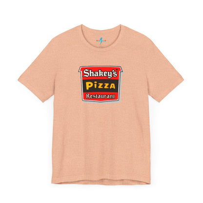 A black Shakey's Pizza - 1980s Retro Logo - Unisex T-Shirt by Printify hangs against a white background. The shirt features a colorful graphic with the text "Shakey's Pizza Restaurant" in white, yellow, and black lettering on a red background, resembling vintage pizza joints signage. This retro tee brings nostalgic vibes of classic pizzerias.