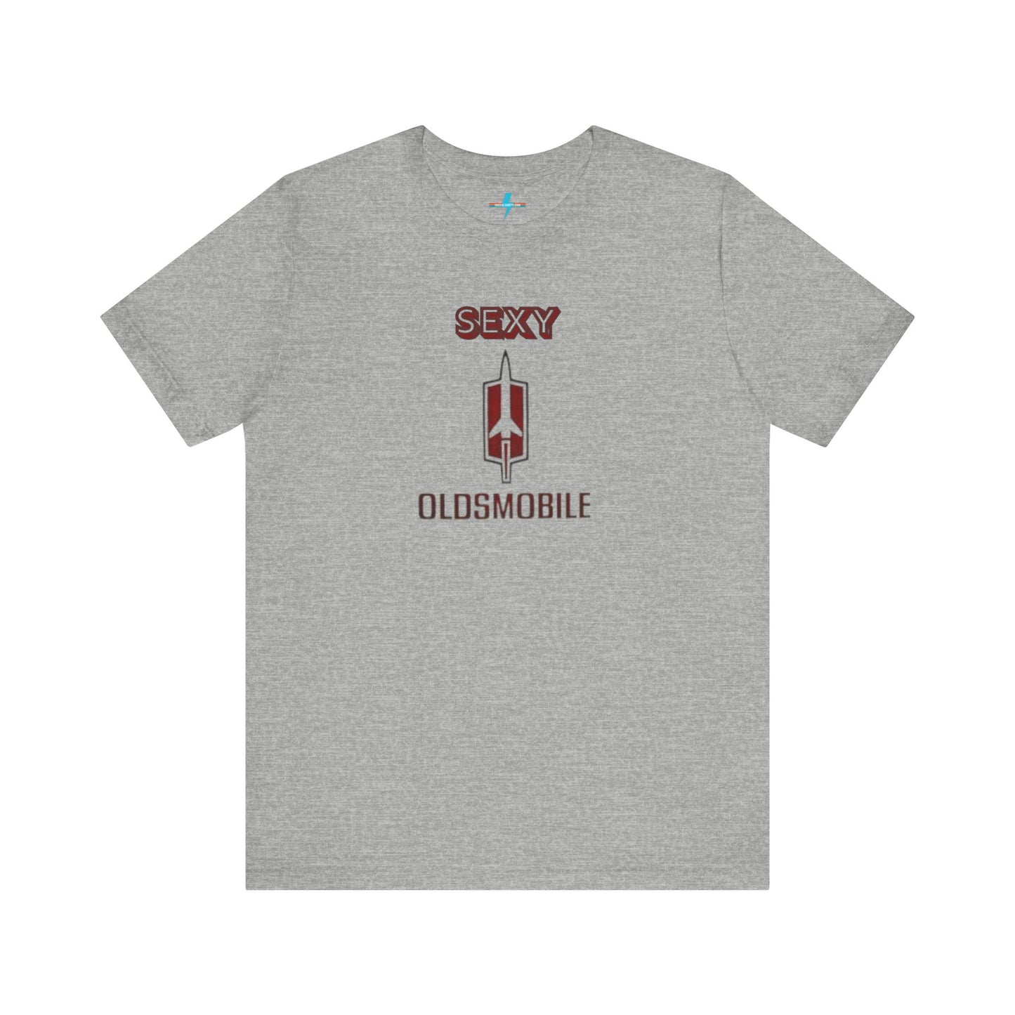 Introducing the Sexy Oldsmobile - Unisex Jersey Short Sleeve Tee by Printify, a light gray t-shirt featuring a striking graphic in the center. The design includes the word "SEXY" in bold red letters above a vertical Oldsmobile logo, underlined by the word "OLDSMOBILE" in red letters. This t-shirt is perfect for vintage car enthusiasts and comedy lovers alike, with its plain white background accentuating the bold design.