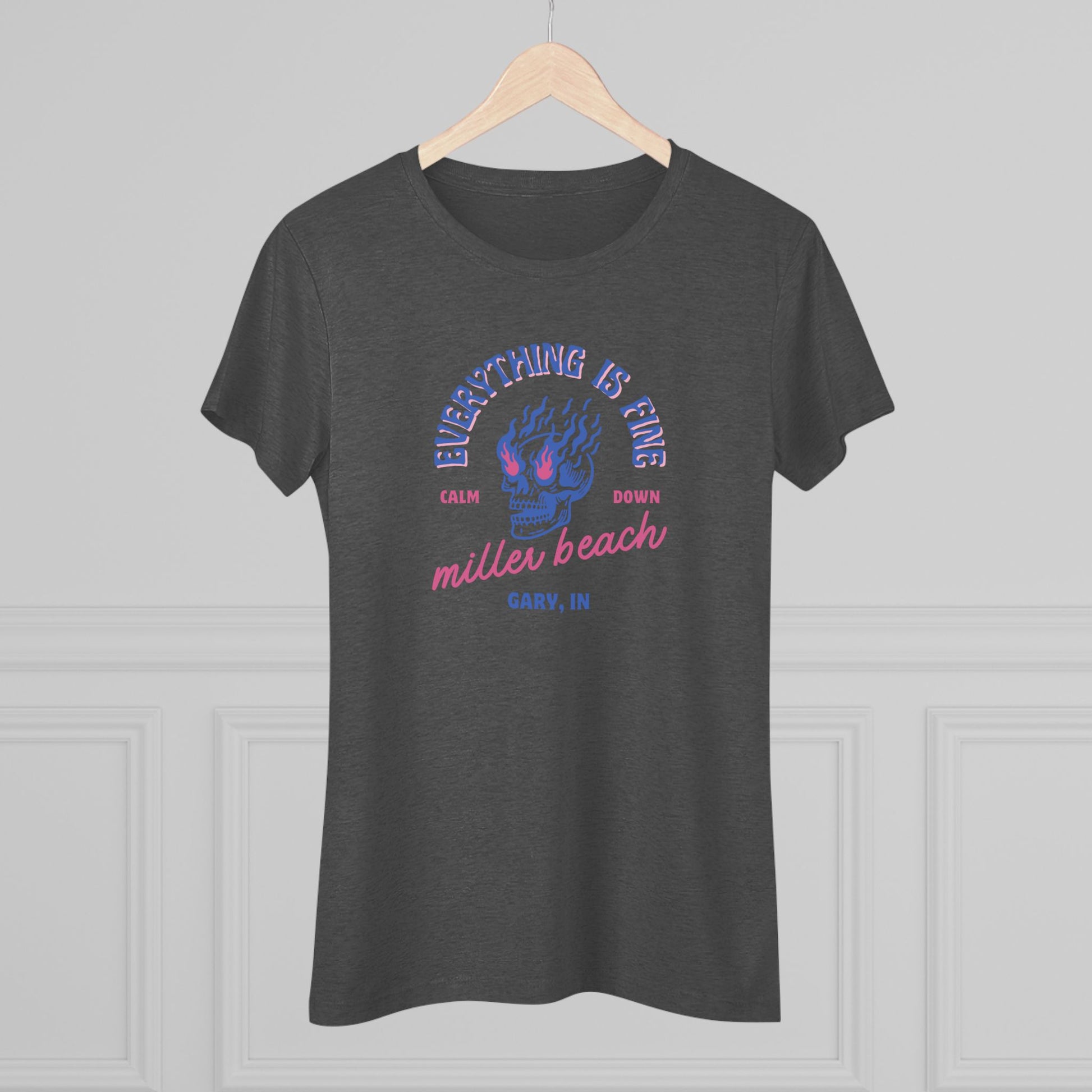 Introducing the Miller Beach - Everything is Fine - Calm Down Women's Triblend Tee by Printify – a dark gray, relaxed-fit shirt adorned with a neon blue and pink flaming skull at its center. Above the skull, the text reads "Everything is Fine" and "Calm Down," while below it says "Miller Beach, Gary, IN" in a stylish script font. This tee captures a cool vintage aesthetic perfect for casual wear.