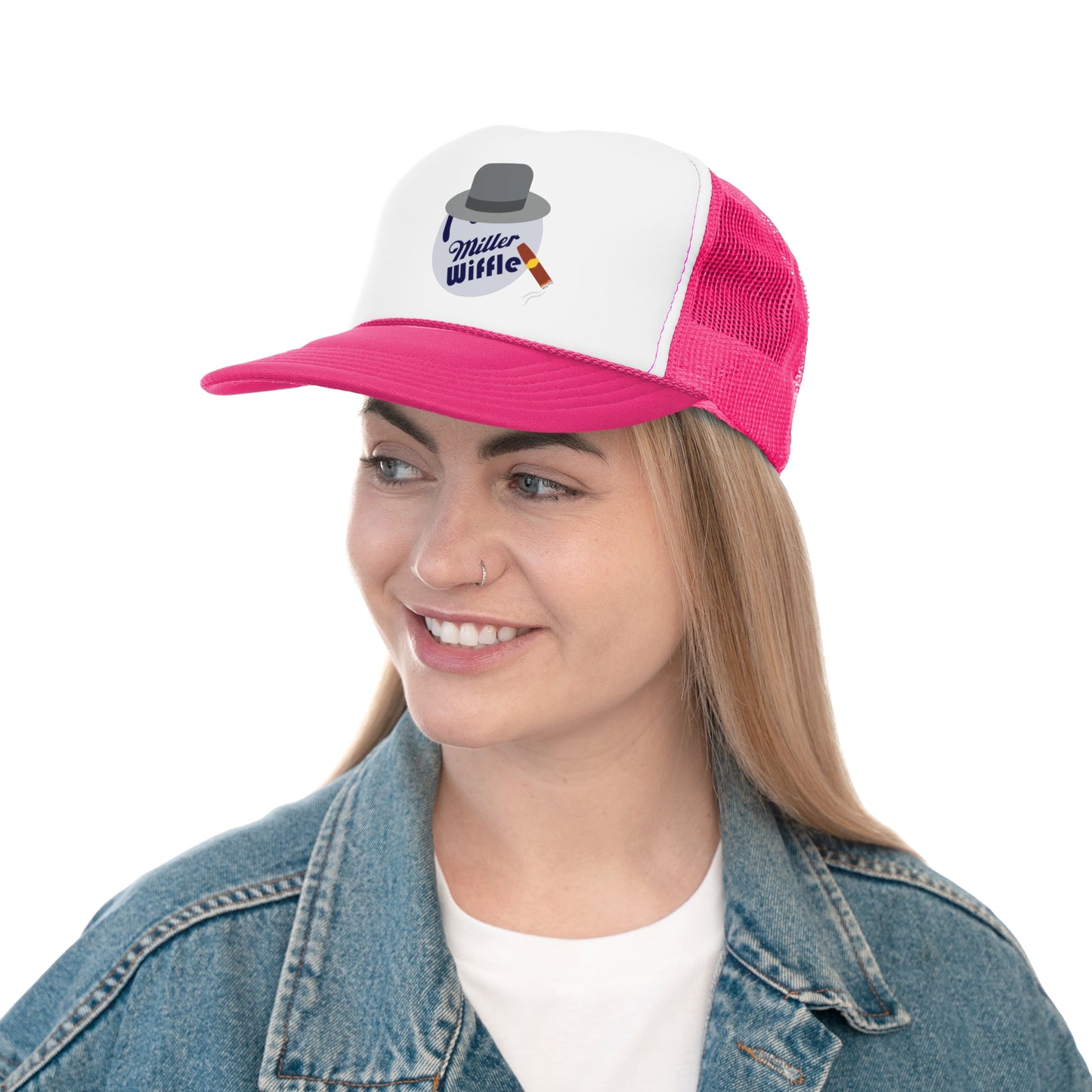 A smiling person with long hair and a nose ring wears the Miller Wiffel Ball ITYSL Driving Crooner Trucker Cap from Printify, which is white and pink and features a graphic of a hat, pipe, and "Miller Wiffle" text. The cap includes an adjustable snap closure for comfort. They are also wearing a blue denim jacket over a white shirt.