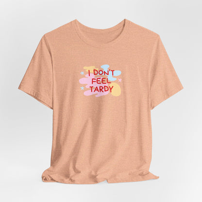 The "I Don't Feel Tardy - 1980s Retro - Unisex Jersey Short Sleeve Tee" from Printify is a light pink jersey shirt that features the bold, colorful text "I DON'T FEEL TARDY" prominently at its center. This design exudes retro vibes with small star shapes and abstract splashes of blue, yellow, and pink, laid flat against a plain background to channel pure Van Halen T-shirt energy.