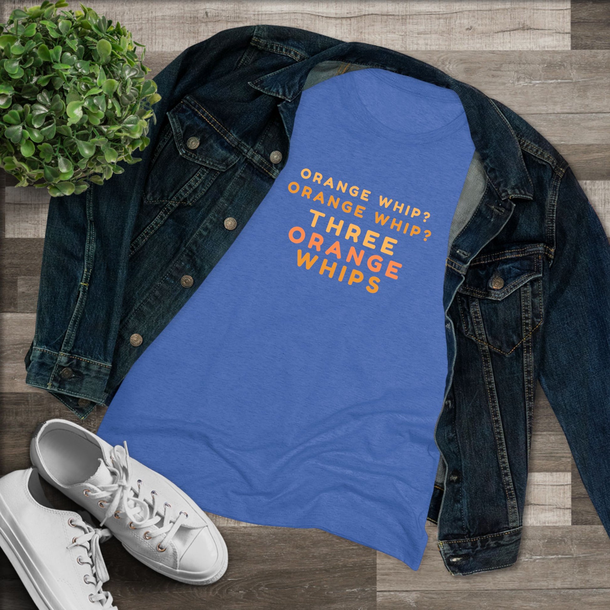 This Blues Brothers women's triblend tee from Printify features a dark gray vintage look with the text "ORANGE WHIP? ORANGE WHIP? THREE ORANGE WHIPS" printed in bright orange and yellow in the center. With a round neck and short sleeves, it's perfect for that retro vibe.