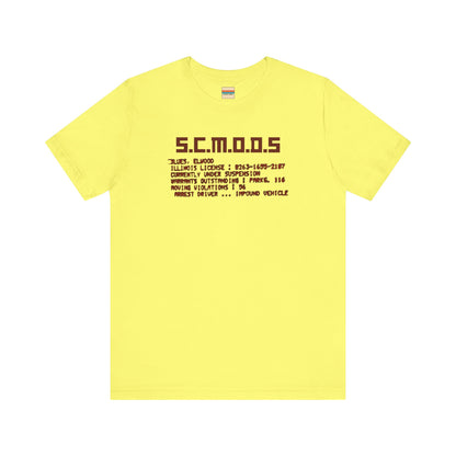 Two yellow "S.C.M.O.D.S. Blues Brother's - Unisex Jersey Short Sleeve Tee" shirts from Printify, featuring "S.C.M.O.D.S" in bold, stylized letters along with smaller text detailing terms like "Illinois," "license," and "impound vehicle." Perfect for fans of The Blues Brothers and Jake and Elwood Blues, the T-shirts are neatly folded and stacked.