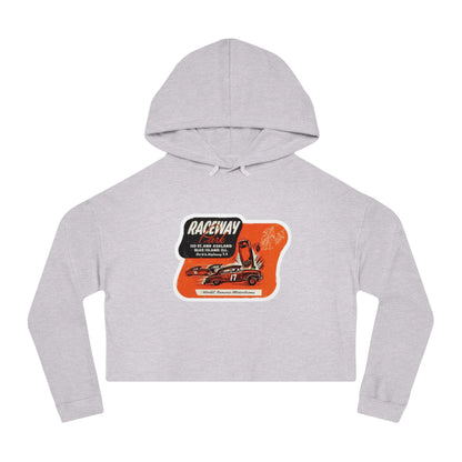 The Raceway Park - Blue Island, IL Women's Cropped Hooded Sweatshirt by Printify features an eye-catching camouflage pattern with a bold red and black "Raceway Park" graphic. Perfect for car enthusiasts, it is adorned with images of cars and text that celebrate a fictional race and hot rod theme, capturing the spirit of Blue Island racers.