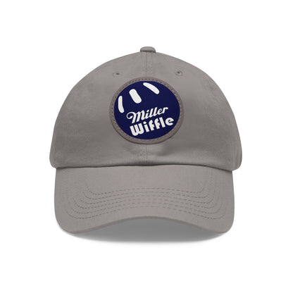 A gray dad hat by Printify, crafted from bio-washed chino twill, featuring a circular blue and white leather patch on the front. The patch showcases a baseball design with "Miller Wiffle" written in cursive font.