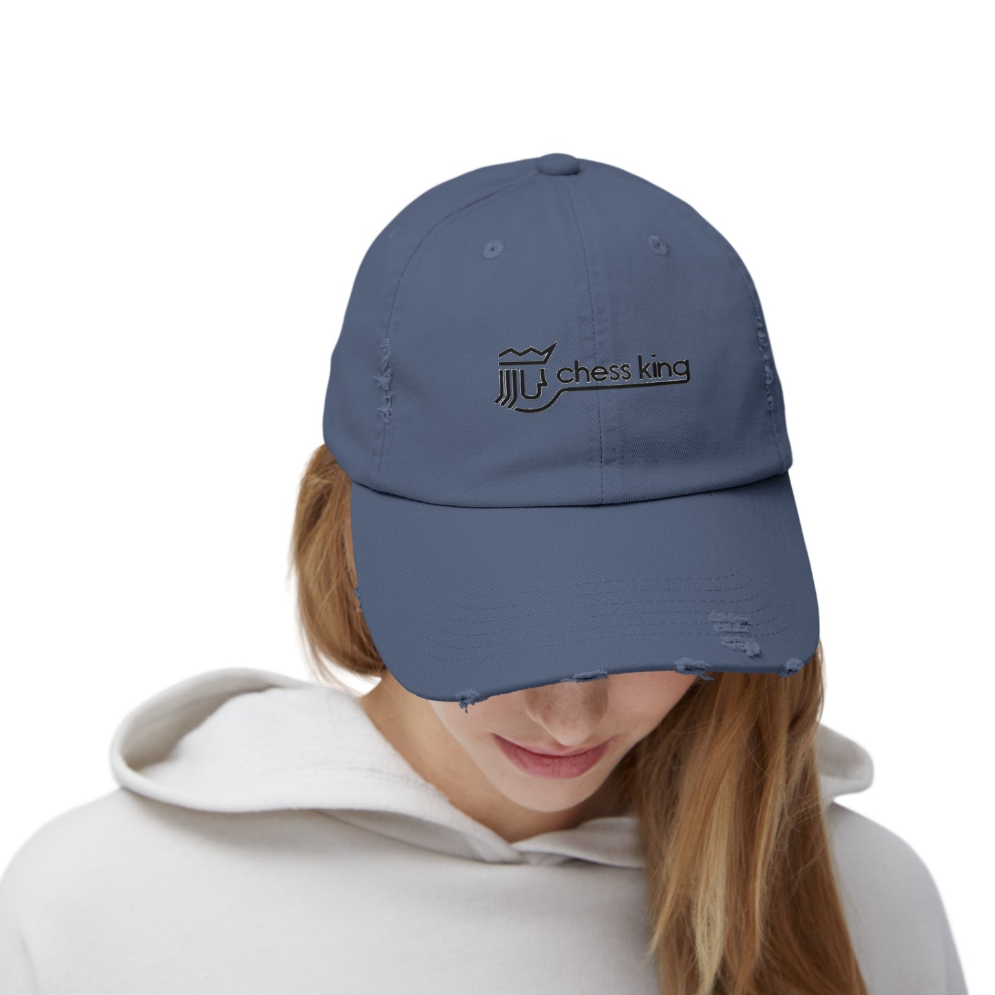 The 1980s Chess King Clothing Store Logo - Unisex Distressed Cap by Printify is a beige baseball cap made from 100% cotton twill. It features intentional distress details and a logo with a crown and rook piece, along with the text "chess king" embroidered on the front, making it a stylish choice for custom caps enthusiasts.