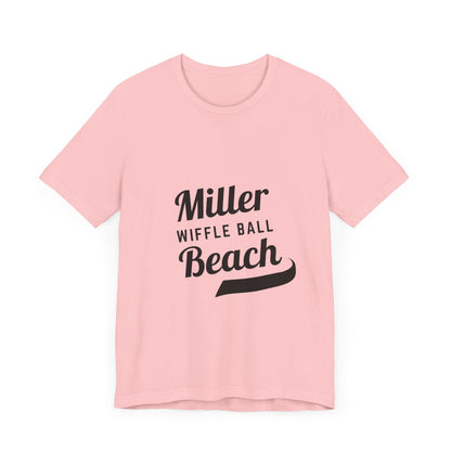 A light blue, soft cotton t-shirt with the text "Miller Beach Wiffel Ball" printed in black on the front. The design features a stylized, curved underline beneath the word "Beach," giving the text a dynamic appearance. This unisex jersey offers a comfortable retail fit for all. Product Name: Miller Beach Wiffel Ball - Unisex Jersey Short Sleeve Tee Retro Logo by Printify.