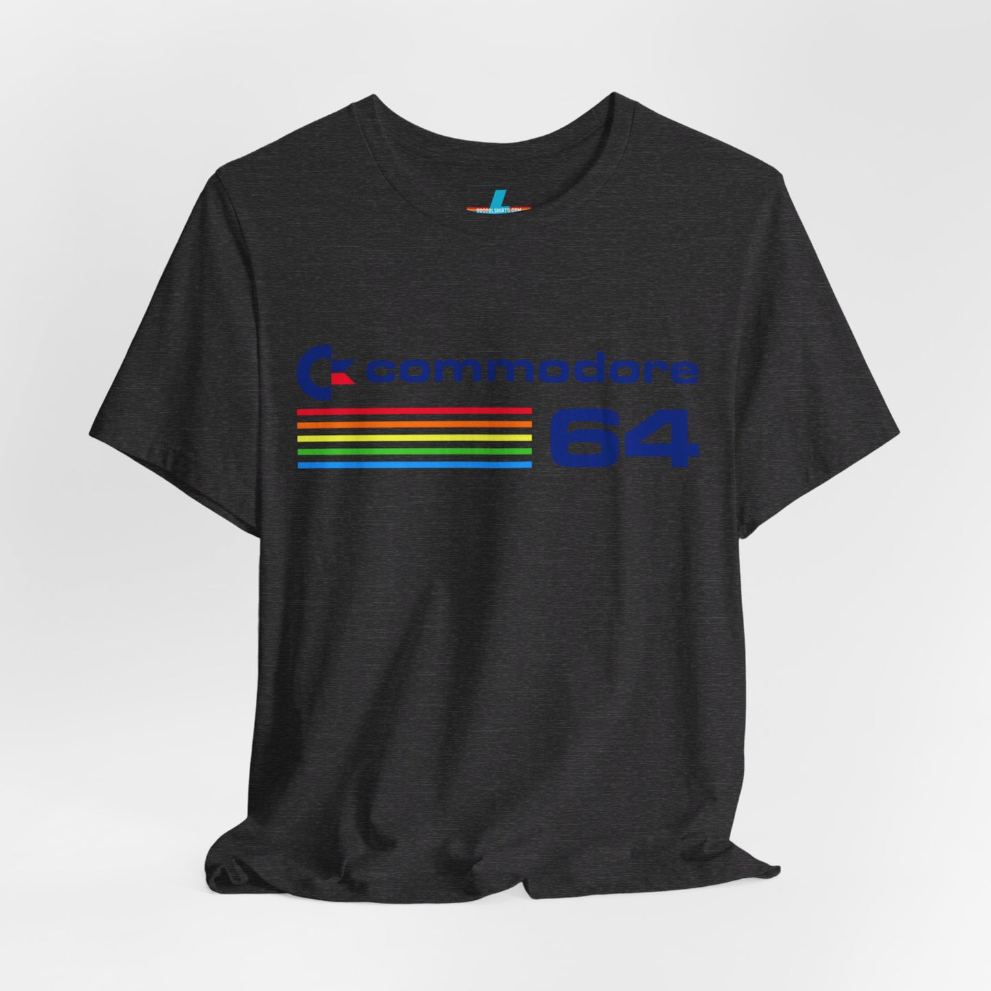 The 1980s Commodore 64 Computer C64 Unisex Jersey Short Sleeve Tee from Printify features a green T-shirt adorned with a vintage design showcasing the text "Commodore 64" and multicolored horizontal lines next to it. The word "Commodore" is emblazoned in blue alongside the Commodore logo, while the number "64" is also highlighted in blue on the right. Ideal for any retro tech enthusiast, this shirt is displayed against a white background.