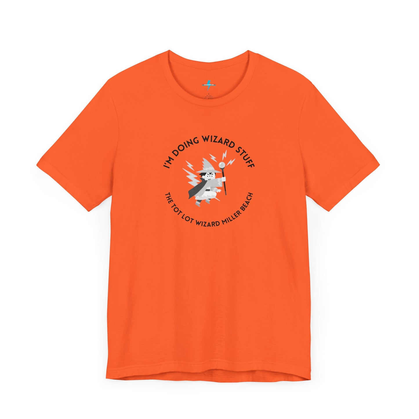 A unisex jersey short sleeve tee in orange from Printify, known as the "Tot Lot Wizard - Miller Beach," features a central graphic of a wizard holding a wand. The design is surrounded by stars and lightning bolts and includes the text "I'M DOING WIZARD STUFF" and "THE TOT LOT WIZARD MILLER BEACH.