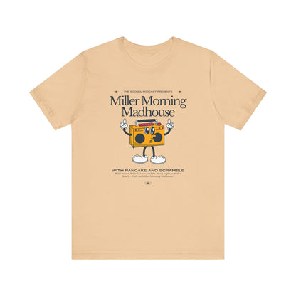 This Printify unisex jersey short sleeve tee in Sand Dune features a playful boombox cartoon character with arms, legs, and sunglasses. Emblazoned with "Miller Morning Madhouse," it highlights podcast details from "The School Podcast Presents.