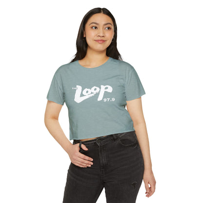 Printify's Women's Festival Crop Top features a grey design with short sleeves and a round neckline. The crop top displays the text "The Loop 97.9" in white, with the word "Loop" styled in a brushstroke-like font—ideal for fans of Chicago’s iconic rock radio station who appreciate retro fashion.