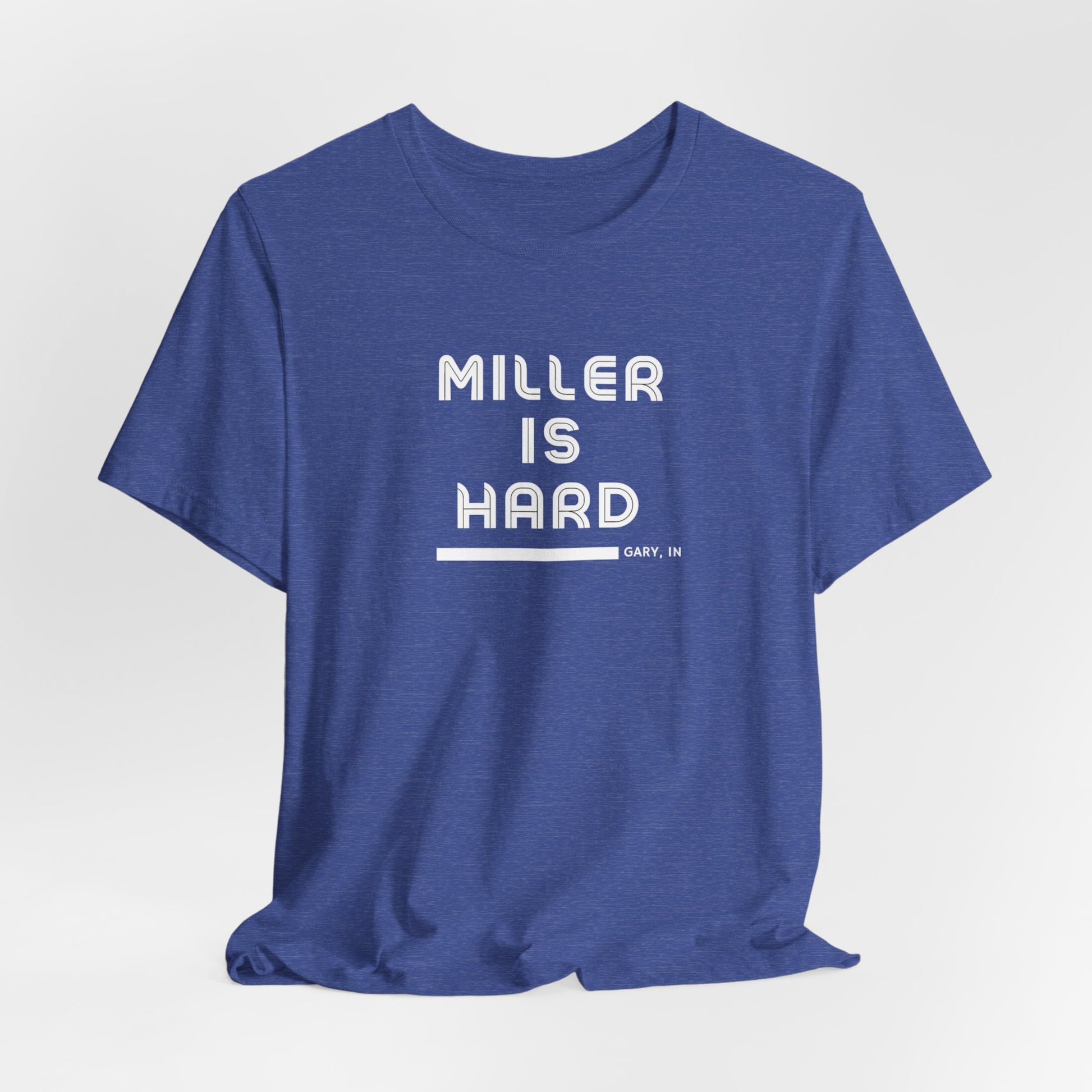 The Miller is Hard - White Letters - Unisex Jersey Short Sleeve Tee by Printify features a rust-colored design with "MILLER IS HARD" printed in bold, white capitals on the front. Below, "GARY, IN." is added in smaller font. This simple yet striking shirt evokes the spirit of Miller Beach with no additional graphics or patterns.