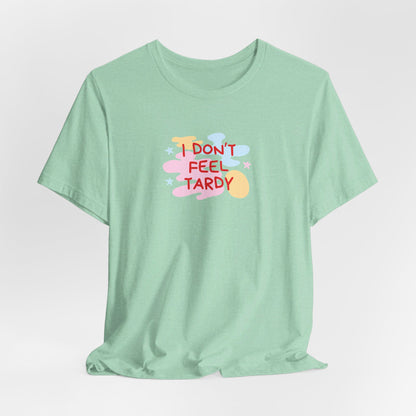 The "I Don't Feel Tardy - 1980s Retro - Unisex Jersey Short Sleeve Tee" from Printify is a light pink jersey shirt that features the bold, colorful text "I DON'T FEEL TARDY" prominently at its center. This design exudes retro vibes with small star shapes and abstract splashes of blue, yellow, and pink, laid flat against a plain background to channel pure Van Halen T-shirt energy.