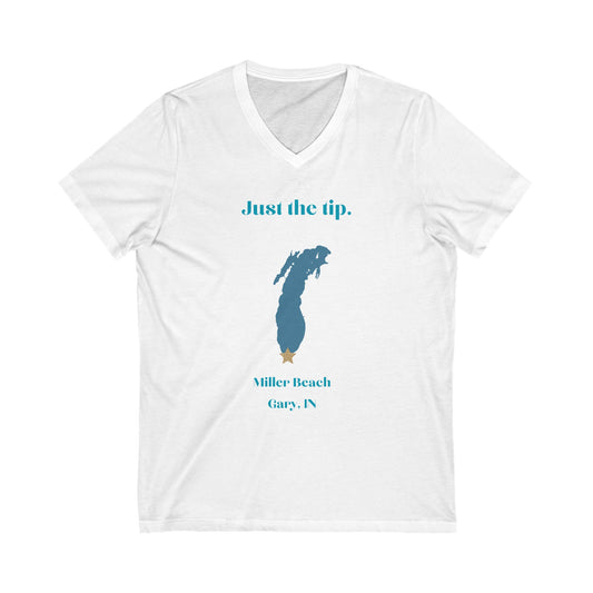 The Printify "Just the Tip - Miller Beach" Unisex V-Neck Shirt is a white t-shirt that showcases a silhouette of Lake Michigan with a gold star at its southern tip. The design includes text, "Just the tip." on top and "Miller Beach, Gary, IN." below, making it an ideal choice for those looking for custom t-shirts to celebrate their favorite beach spot.