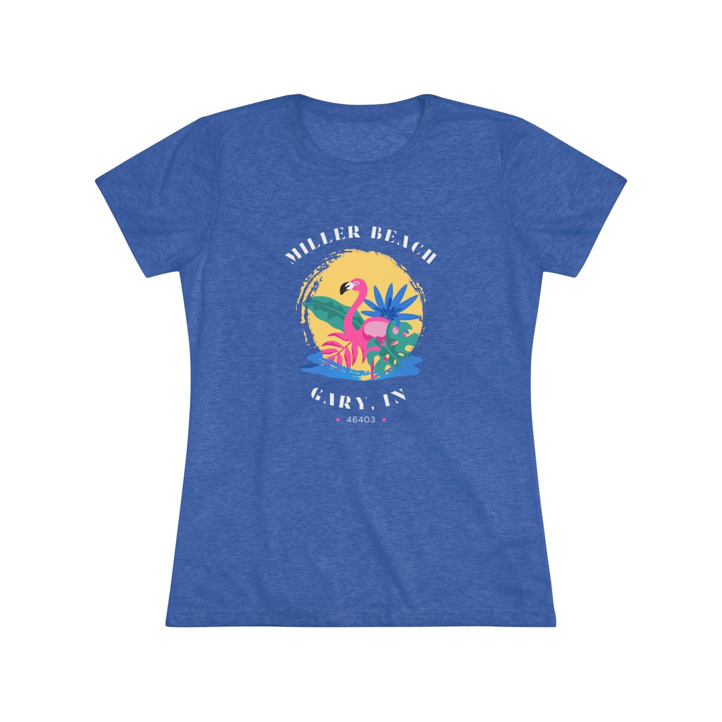 A women's triblend tee from Printify, the Miller Beach Flamingo features a blue color and "Miller Beach Gary, IN 46403" text with a vibrant design of a flamingo amidst tropical foliage for a vintage aesthetic. This t-shirt is showcased on a wooden surface alongside a denim jacket, white sneakers, and a potted plant.