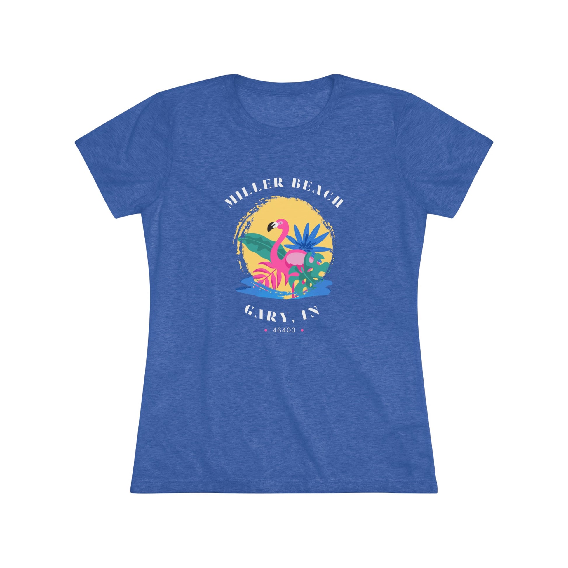 A women's triblend tee from Printify, the Miller Beach Flamingo features a blue color and "Miller Beach Gary, IN 46403" text with a vibrant design of a flamingo amidst tropical foliage for a vintage aesthetic. This t-shirt is showcased on a wooden surface alongside a denim jacket, white sneakers, and a potted plant.