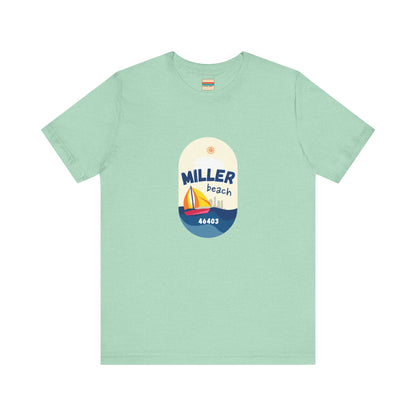 The Miller Beach Sailboat - Unisex Jersey Short Sleeve Tee by Printify features a vibrant graphic design portraying a sailboat on water with a sun above it and the text "MILLER beach 46403." This white retail fit shirt is crafted from soft Airlume combed cotton and showcases rounded graphics in blue, orange, and yellow.