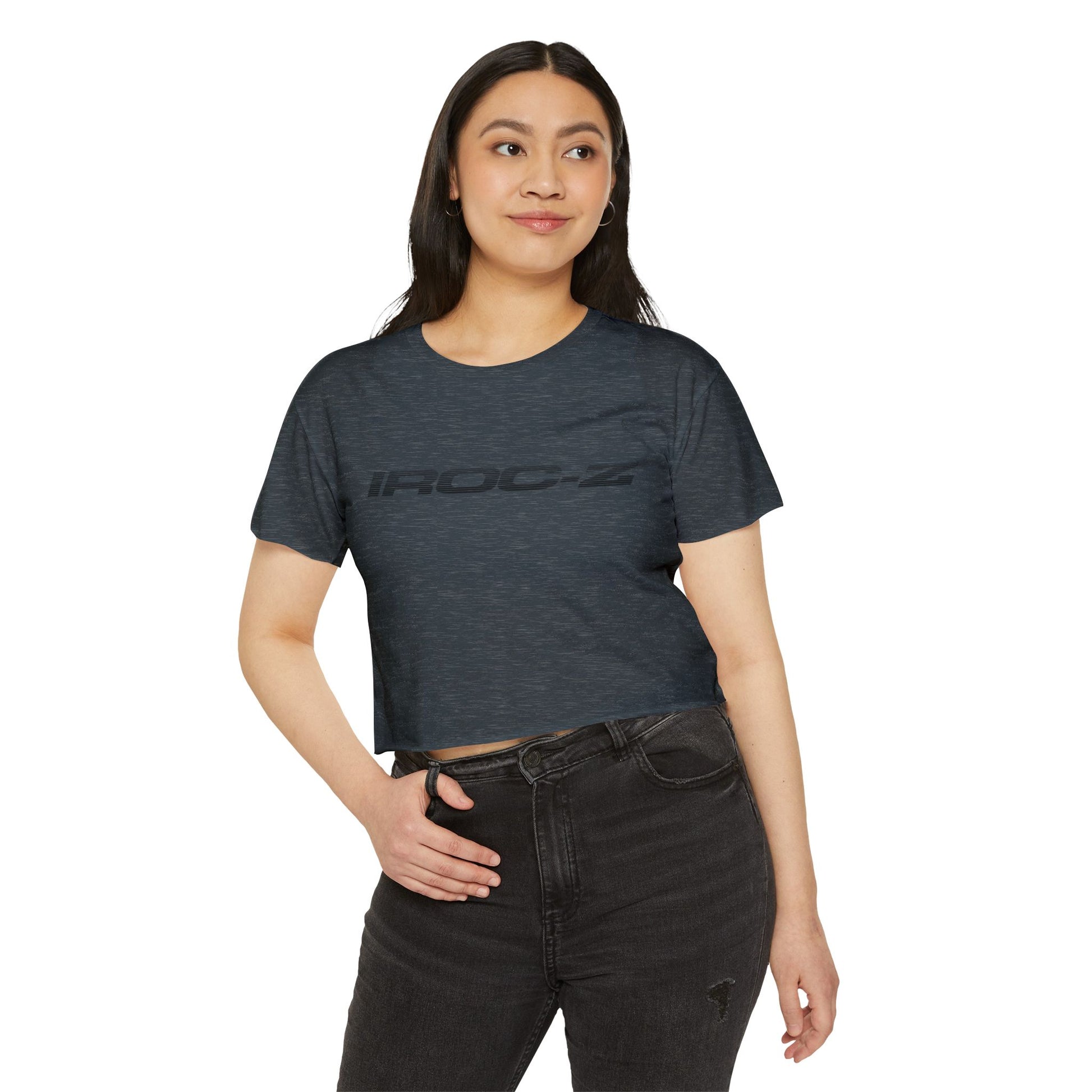 A grey, short-sleeve, rounded-neckline Women's Festival Crop Top by Printify, featuring "IROC-Z" printed in bold black letters across the chest. Perfect for any festival, this Chevrolet Iroc Z-inspired top from the 1980s stands out against a plain white background.