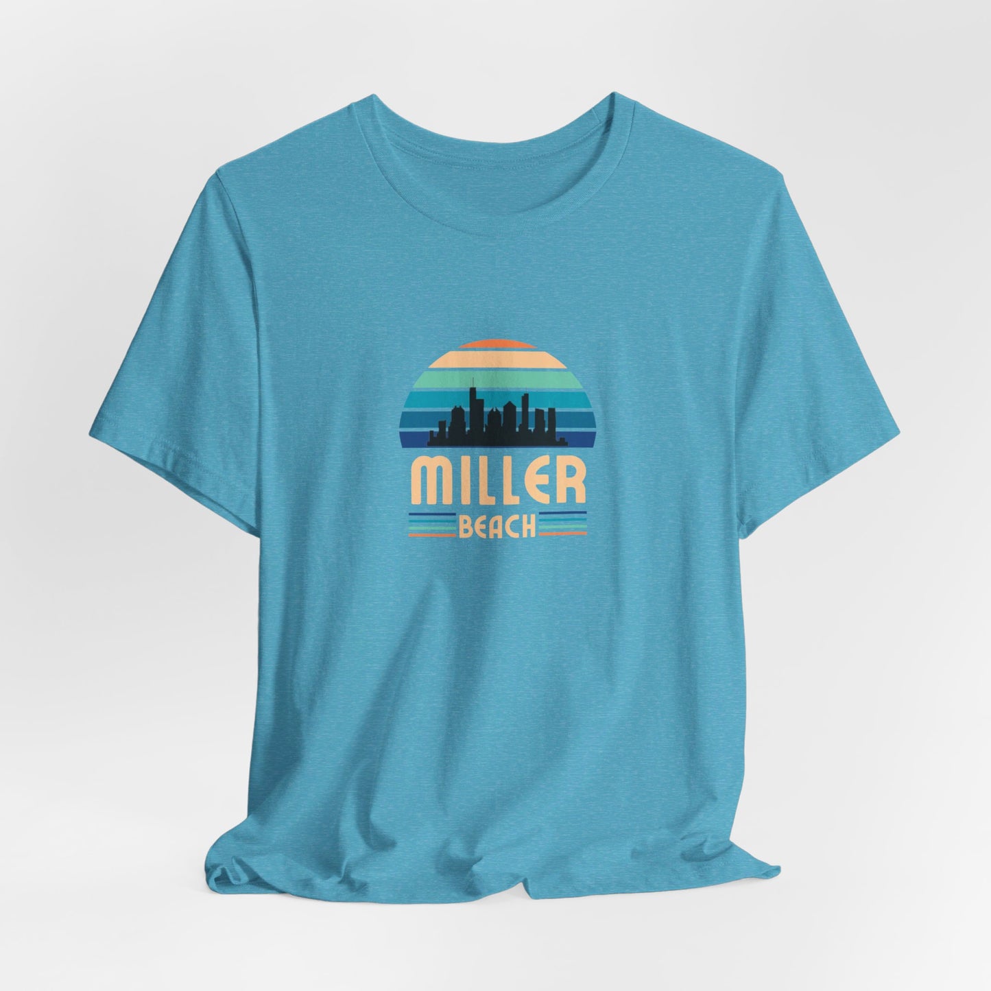 A brown unisex jersey short sleeve tee called "Miller Beach Chicago Skyline" from Printify features a vintage-style design with a sunset, the Chicago skyline, and "Miller Beach" in bold letters. The design incorporates shades of blue, orange, and yellow and is displayed against a plain white background.