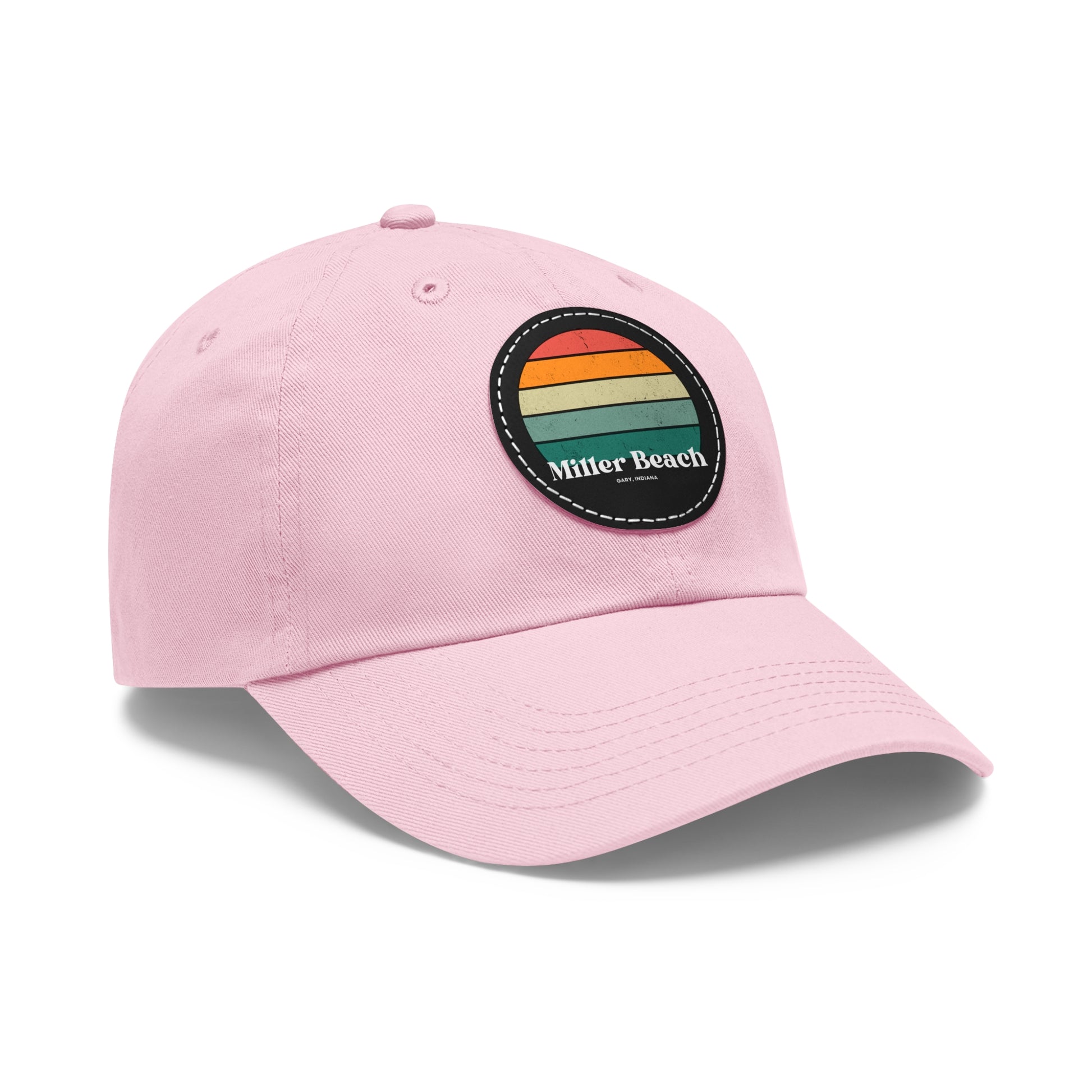 The Miller Beach Retro Sunset - Dad Hat with Leather Patch (Round) by Printify is a pink baseball cap crafted from bio-washed chino twill for added comfort. It features a PU leather patch adorned with horizontal stripes in red, orange, yellow, green, and blue. Below the stripes, "Miller Beach" is embroidered in white. An adjustable strap at the back ensures a perfect fit.