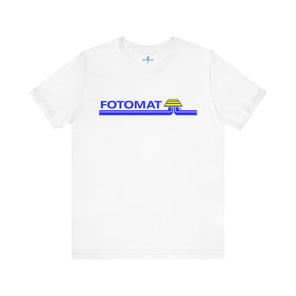 The Fotomat 1970s Retro T-Shirt by Printify is a dark gray short-sleeve shirt that features the word "FOTOMAT" in bold blue capital letters and a blue and yellow graphic design resembling layered lines and an upside-down triangle. This Tshirt captures the essence of 80s nostalgia with its centered, retro design.