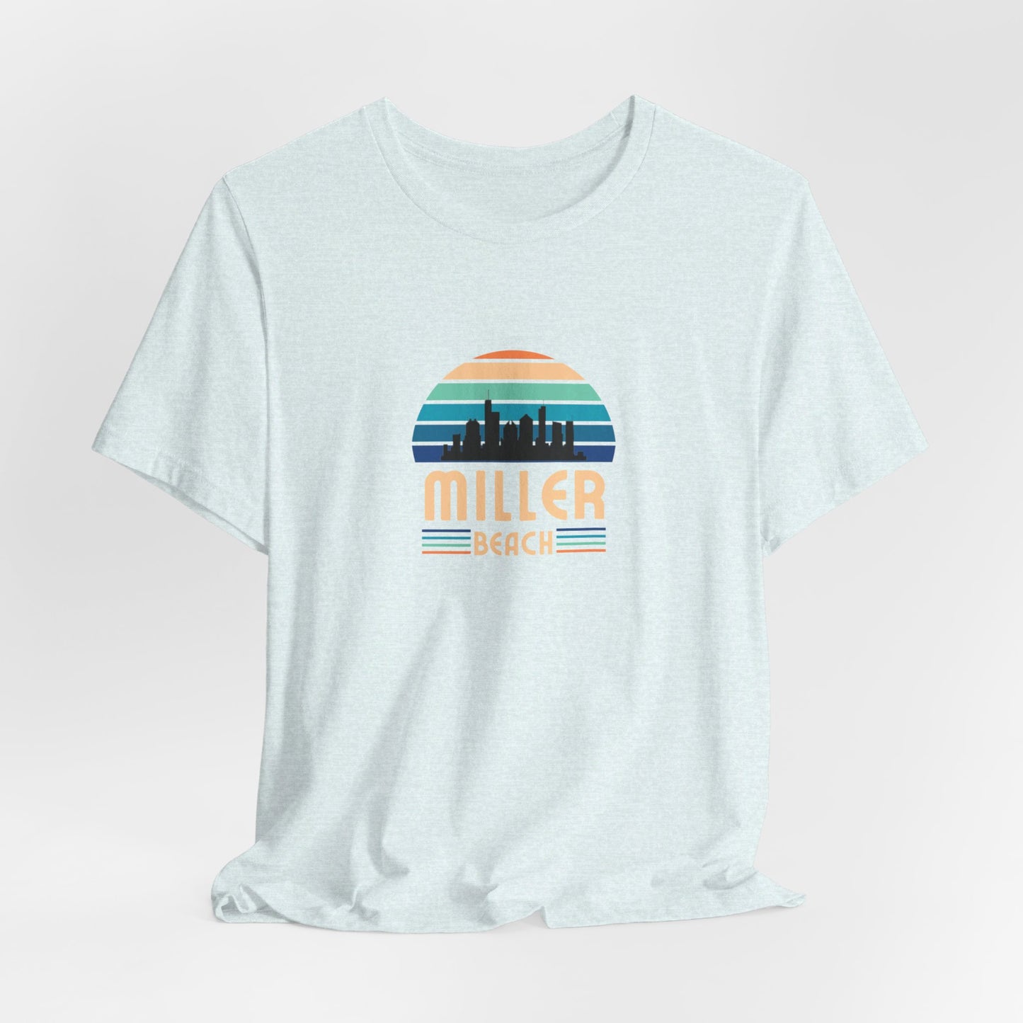 A brown unisex jersey short sleeve tee called "Miller Beach Chicago Skyline" from Printify features a vintage-style design with a sunset, the Chicago skyline, and "Miller Beach" in bold letters. The design incorporates shades of blue, orange, and yellow and is displayed against a plain white background.