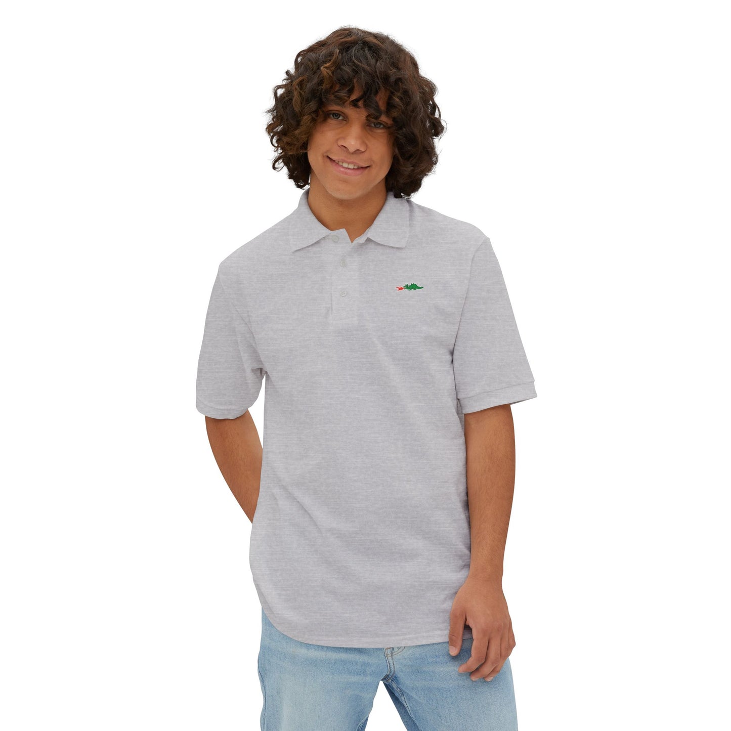 A person with curly hair wearing a navy blue Printify Braggin' Dragon - 1980s Sears Men's Piqué Polo, featuring a small embroidered dragon logo on the left chest, smiles against a plain white background.