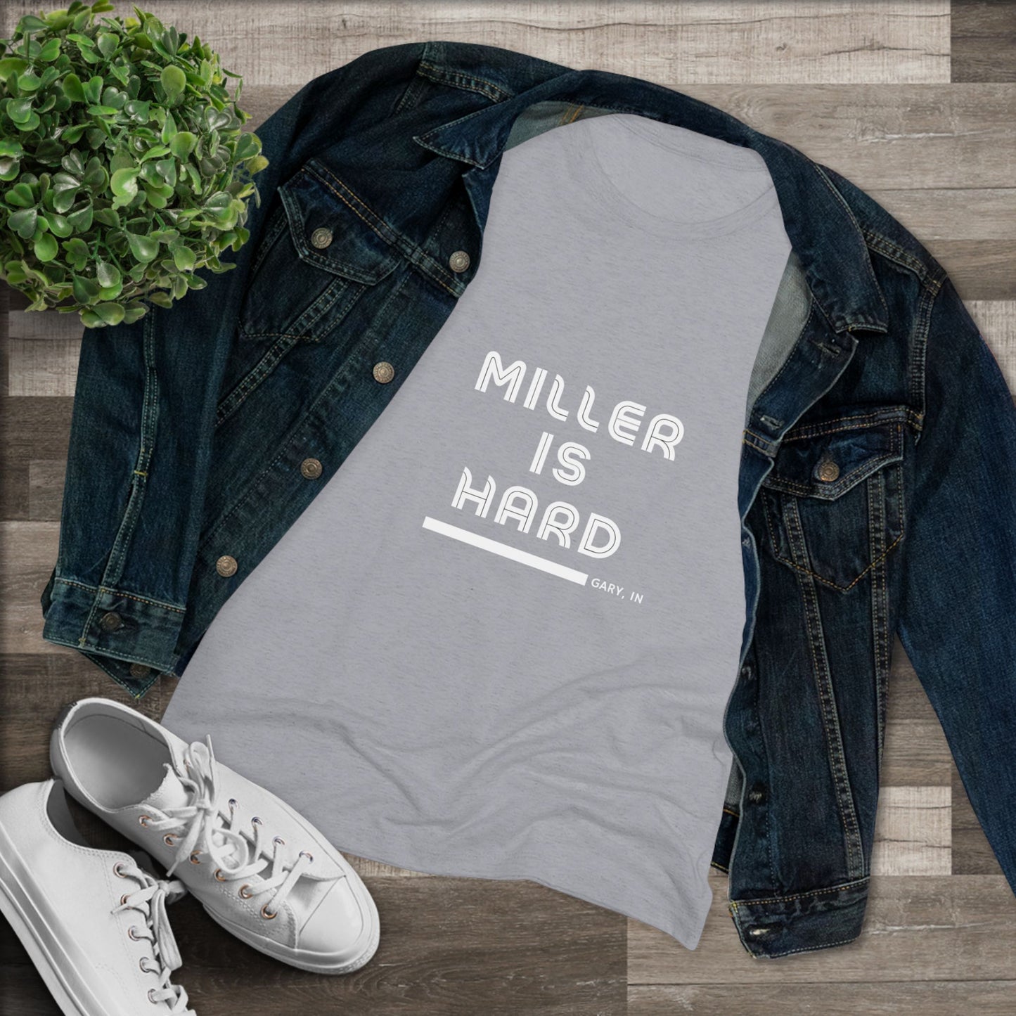 The Miller is Hard - Miller Beach Women's Triblend Tee by Printify features unique red coloring with white text that reads "MILLER IS HARD" and "GARY, IN" below, showcasing distinctive lettering spacing and alignment. Made from ultra-soft fabric, this shirt ensures a comfortable fit with a simple, casual design.