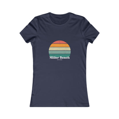 The Printify Women's Favorite Tee - Miller Beach Gary, IN Retro Sunset is a pink women's T-shirt showcasing a retro-style graphic of a sun with horizontal stripes in orange, yellow, and green. Designed with a feminine fit, the airlume combed cotton fabric offers premium softness. Below the sun, the text reads "Miller Beach" in white, with smaller text underneath that is not legible.