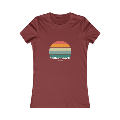 The Printify Women's Favorite Tee - Miller Beach Gary, IN Retro Sunset is a pink women's T-shirt showcasing a retro-style graphic of a sun with horizontal stripes in orange, yellow, and green. Designed with a feminine fit, the airlume combed cotton fabric offers premium softness. Below the sun, the text reads "Miller Beach" in white, with smaller text underneath that is not legible.