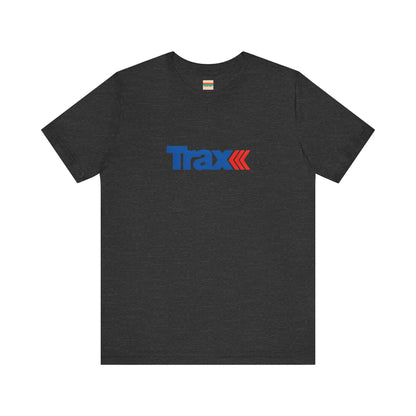 A gray unisex jersey short sleeve tee from Printify, inspired by retro 1980s Kmart style. The "Trax" logo is printed in blue letters, followed by three red arrows pointing to the right. This classic Trax Brand T-shirt is laid flat against a white background, capturing nostalgic fashion vibes.