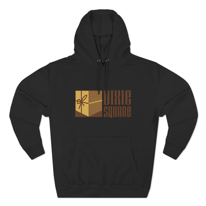 A black hoodie from Printify, named "Dixie Square 1960s Logo - Harvey, IL - Three-Panel Fleece Hoodie," featuring the words "Dixie Square" in brown stylized block letters on the front. Embracing a retro charm, the design also includes a graphic of a gold-colored square with a scissors icon and vertical lines, reminiscent of Dixie Square Mall's heyday.