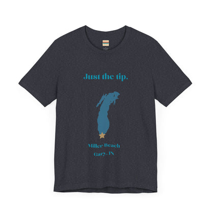 The Just the Tip - Miller Beach Unisex Jersey Short Sleeve Tee by Printify in yellow showcases text and a graphic design. The top displays "Just the tip" above a blue silhouette reminiscent of Indiana. At the bottom, it reads "Miller Beach" and "Gary, IN." Made from soft Airlume combed cotton, this tee offers both comfort and style.