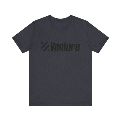 A unisex jersey short sleeve tee from Printify, featuring a classic 1980s Venture Stores logo printed in bold black letters across the chest on a gray fabric, is showcased against a plain white background.