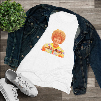 A Women's Triblend Tee by Printify, titled "Helen Roper - Three's Company," features a red design with an illustration of a smiling person with curly hair and colorful clothing. Below the illustration, the text "Helen Roper" is written in a bold, retro font, capturing the essence of vintage TV humor.