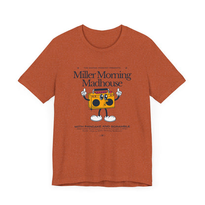 This Printify unisex jersey short sleeve tee in Sand Dune features a playful boombox cartoon character with arms, legs, and sunglasses. Emblazoned with "Miller Morning Madhouse," it highlights podcast details from "The School Podcast Presents.